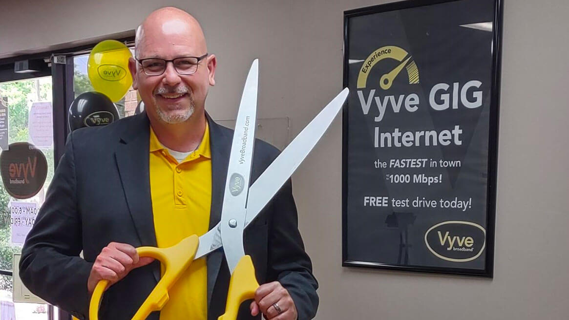 Vyve Sales team member posing with oversized scissors